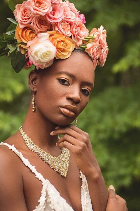 Beauty portrait with a sculptural rose headdress and warm light.