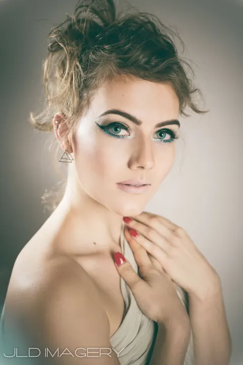 Soft beauty portrait with green eye makeup and an elegant updo.