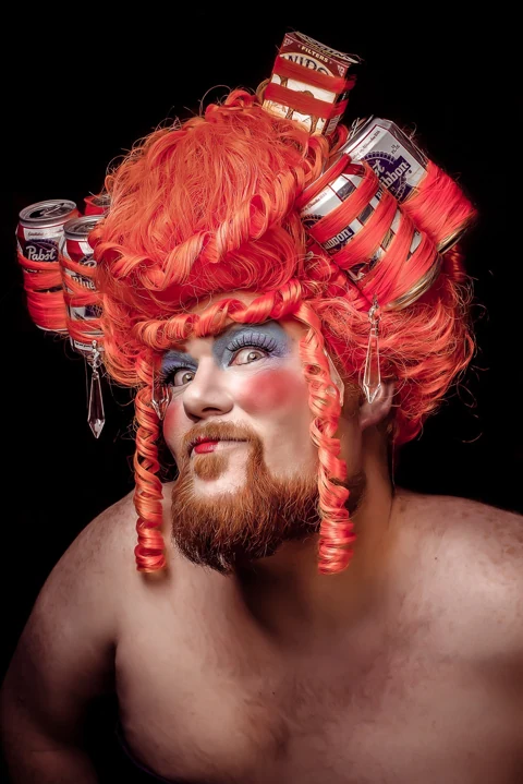 Theatrical portrait with an elaborate headdress made from beverage cans.