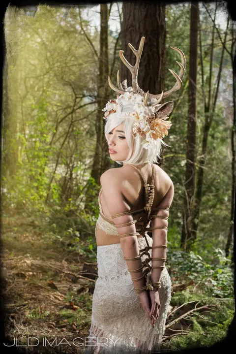 Profile of an antlered woodland character in a white costume.
