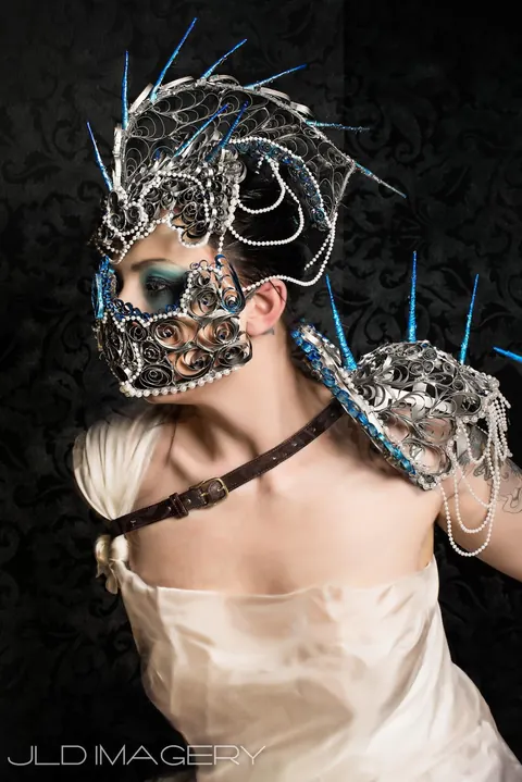 Fantasy portrait with an intricate metallic mask and sculptural armor.