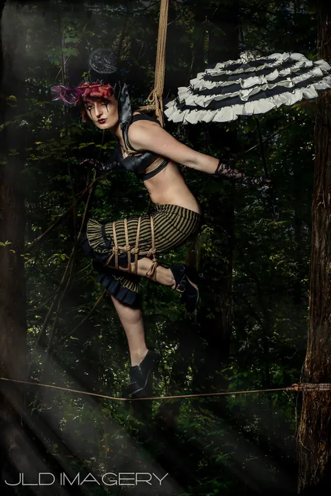 Woodland fantasy character posed beside a graphic wall of playing cards.