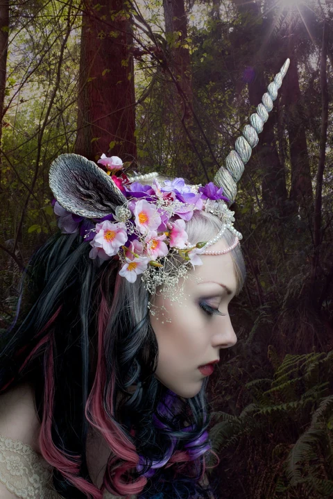 Detail of a floral unicorn headpiece in a woodland portrait.