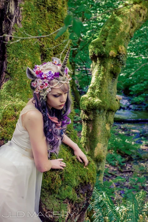 Woodland fantasy portrait framed by moss and soft light.