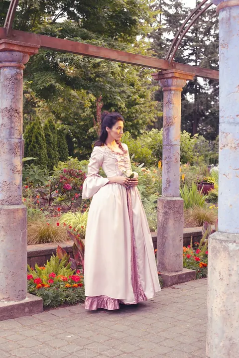 Period fashion portrait in a formal garden.