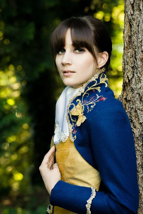 Outdoor portrait in an embroidered blue period jacket.