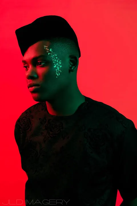 Graphic portrait against red and blue light with a sculptural flat-top hairstyle.