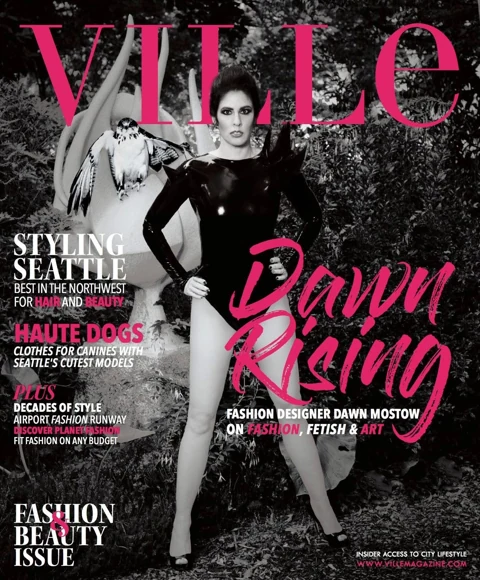VILLE Magazine cover, Fashion & Beauty Issue Fall 2017: Dawn Mostow in a black latex bodysuit standing in a forest setting with Alfred the Augur Buzzard on her outstretched arm, "Dawn Rising" cover line in pink script.